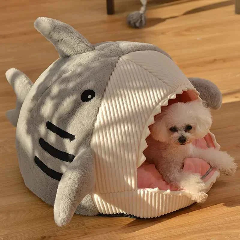 Grey shark cat bed cave with open entrance, ribbed white cushion, small pet inside
