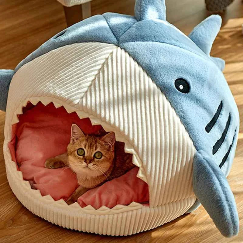 Blue shark cat bed cave with open front and ribbed white cushion, cat resting inside