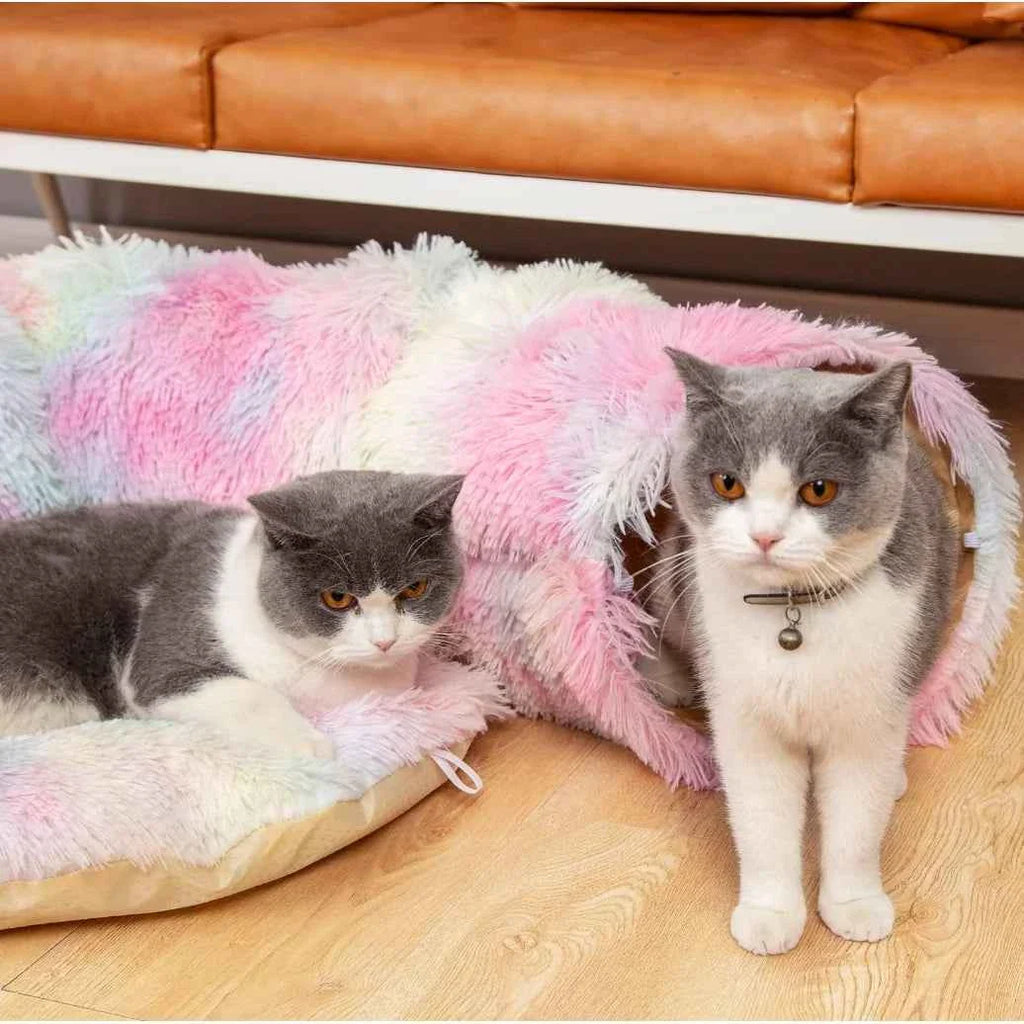 Pink and pastel plush cat tunnel bed with two cats and hanging pom-pom toy