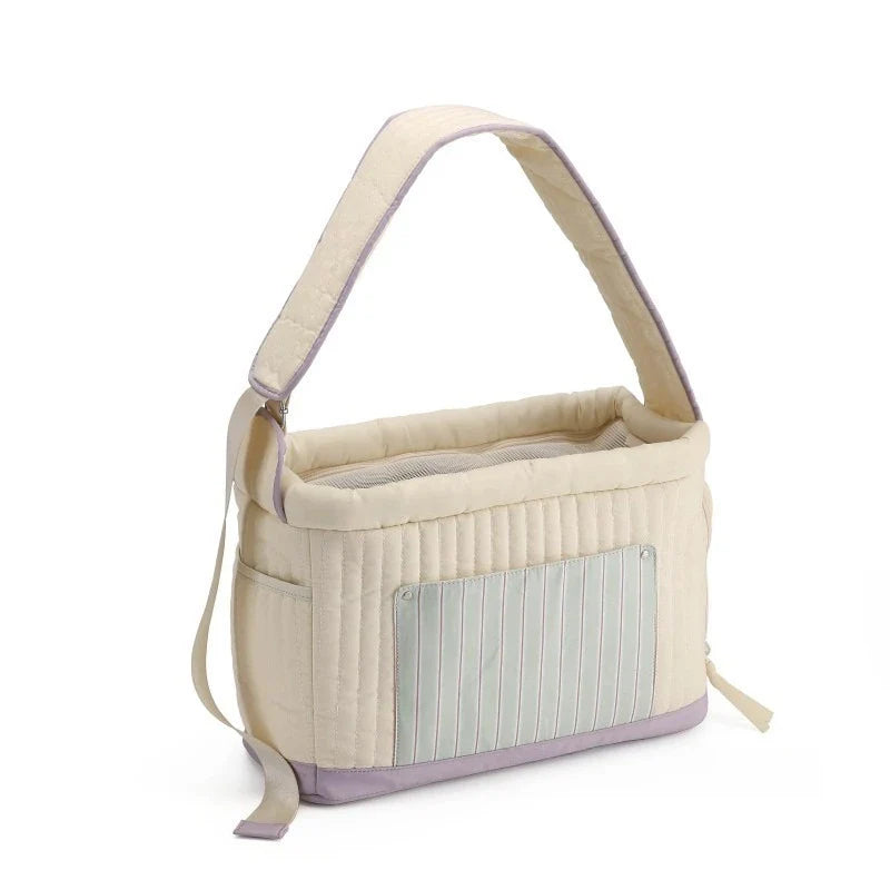 Cream cat carrier sling bag with blue striped front panel and purple base