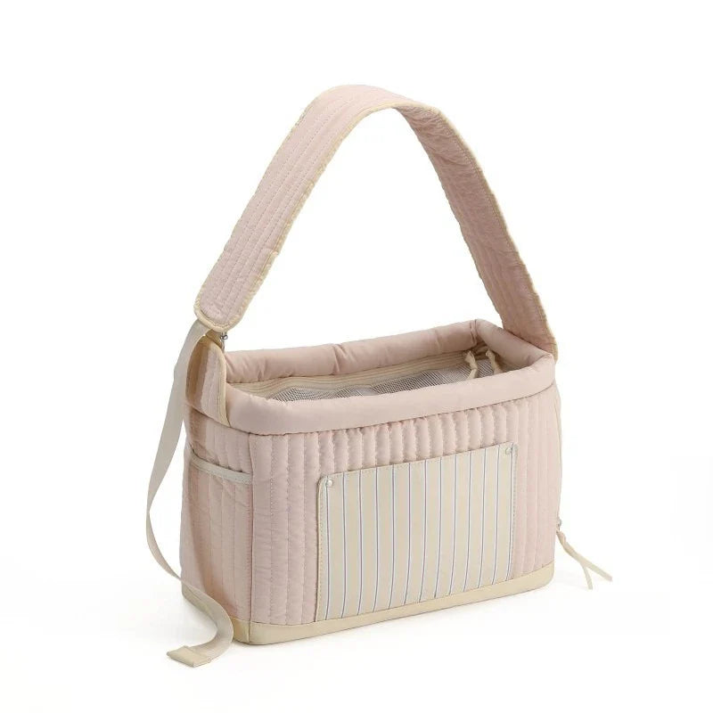 Light pink cat sling carrier bag with quilted sides and blue striped front pocket