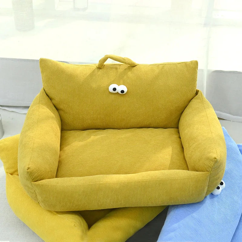 Yellow plush pet sofa bed with padded sides, handle, and cartoon face on backrest