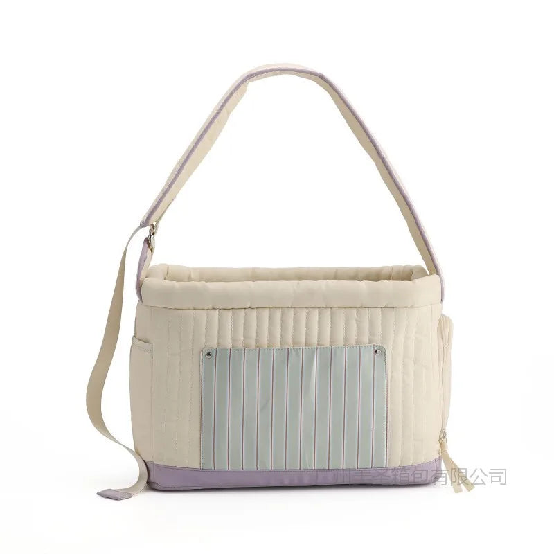 White/cream cat sling carrier with blue striped front panel and purple bottom trim
