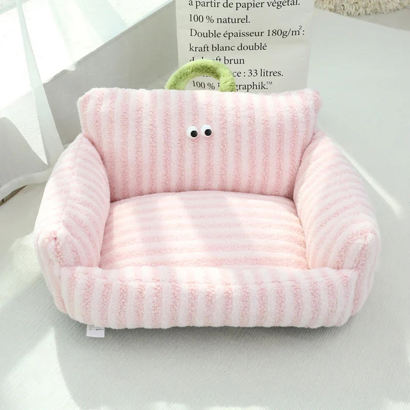 Pink plush pet sofa bed cushion with rounded arms and face patch