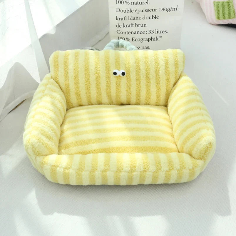 Yellow plush pet sofa bed with striped cushion and cartoon face on backrest