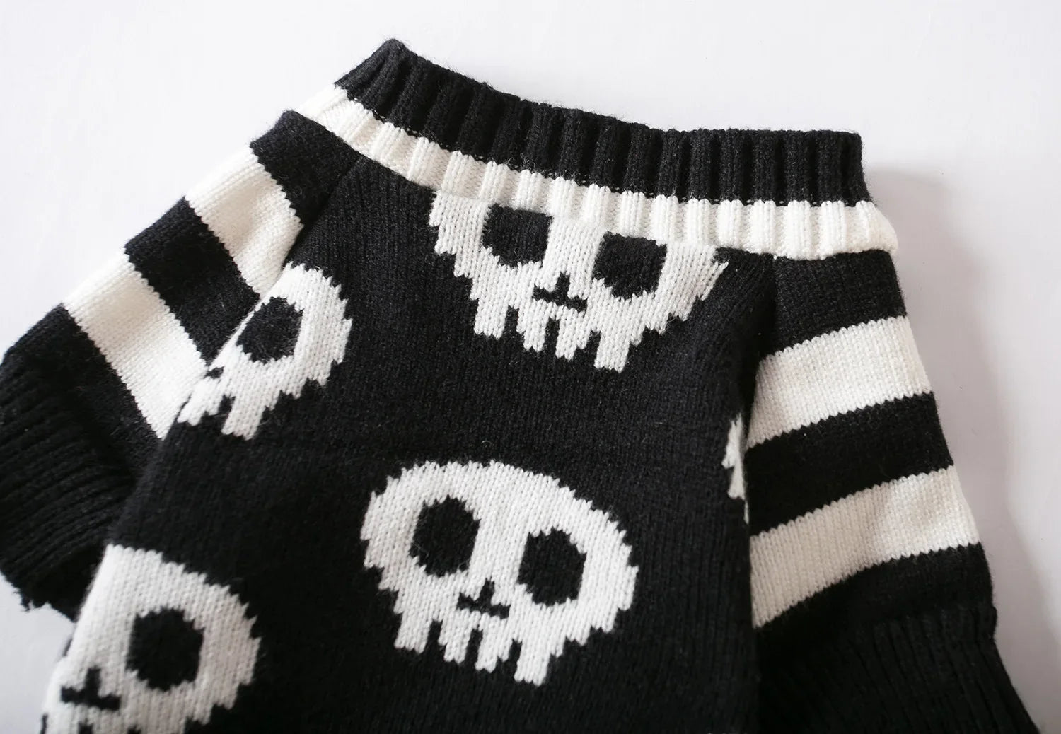 Close-up skull motif knitted sweater in black and white, with ribbed collar