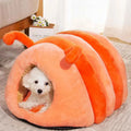 Orange plush caterpillar pet bed tunnel with stripes; small dog resting inside