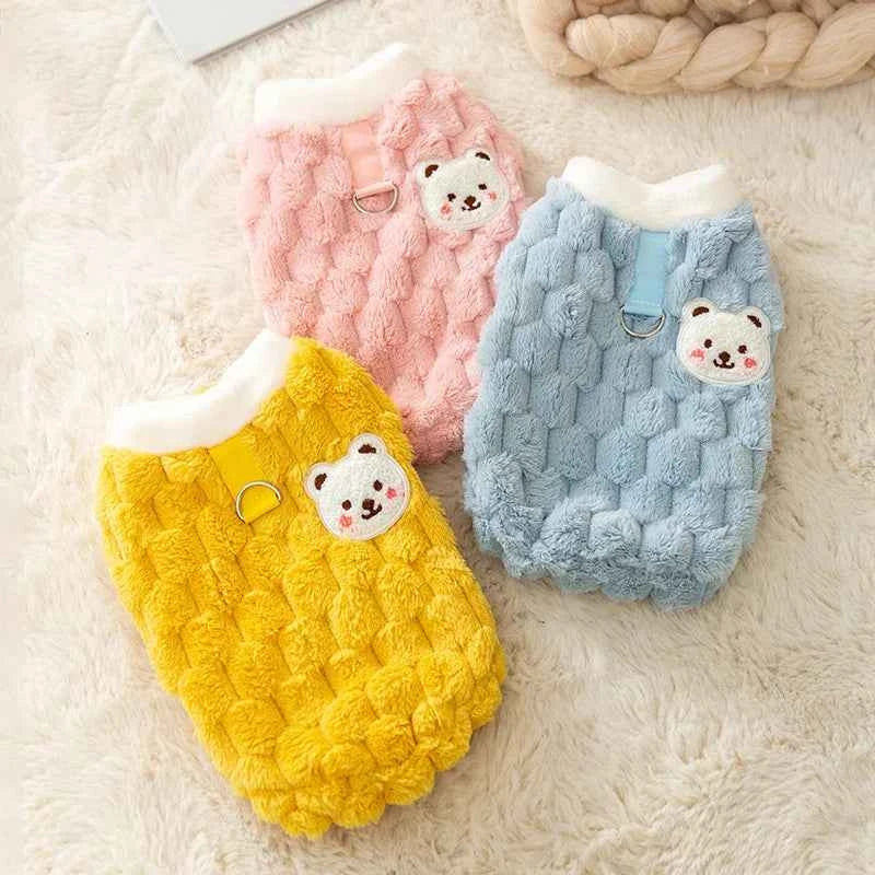Plush cat sweater vest in yellow, pink, and light blue with bear-face patch and arm openings
