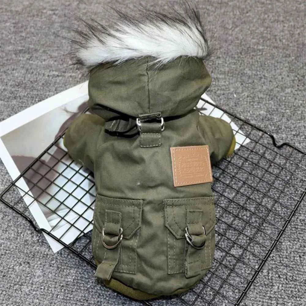 Olive dog parka close-up: faux-fur hood, tan patch, and chest harness strap rings