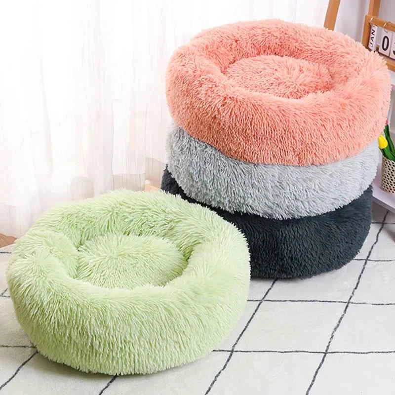 Stacked round donut pet beds showing pink, grey, dark grey, and light green plush