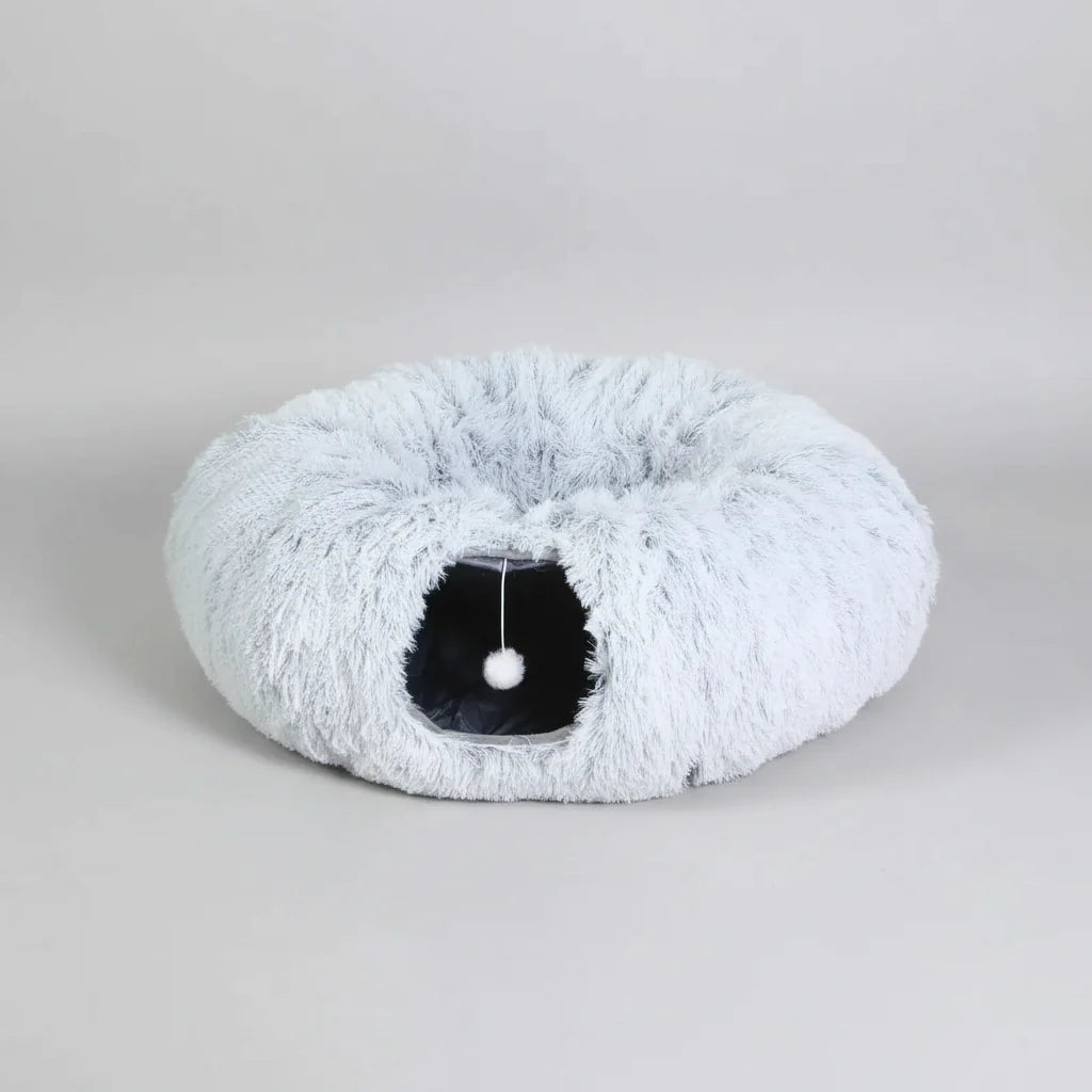 Light grey plush cat tunnel bed with oval tunnel opening and dangling pom-pom