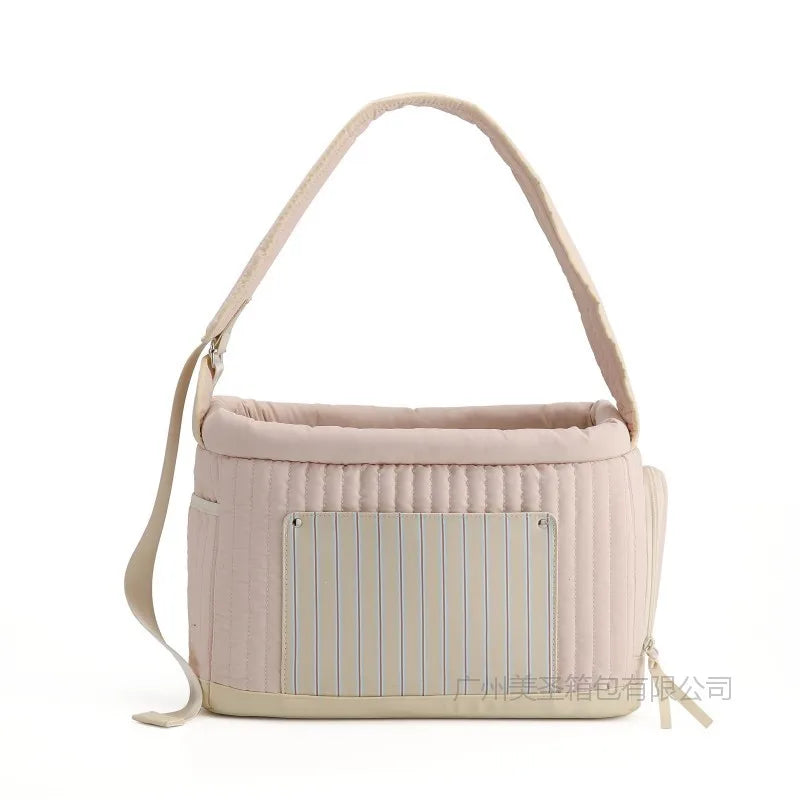 Light pink cat sling carrier bag with blue striped front panel and padded top edge