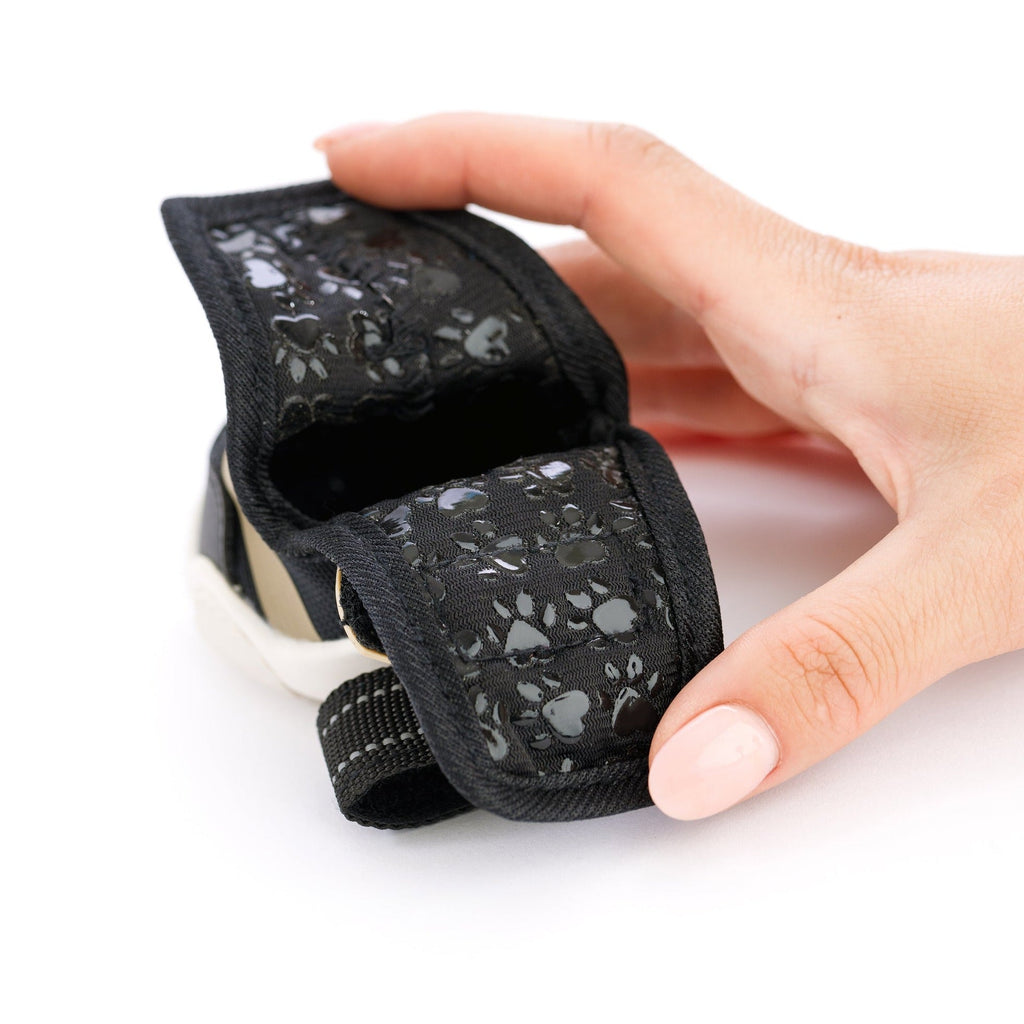 Kai- Dog sneaker close-up: black Velcro strap with paw-print texture and white sole