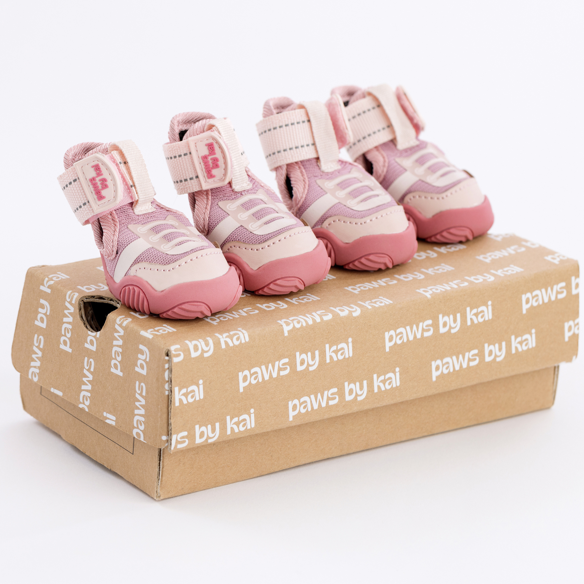 Kai- Dog sneakers in pink with Velcro straps and white soles on a shoebox