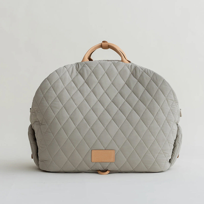 Light gray quilted pet handbag back view with top handle and tan patch