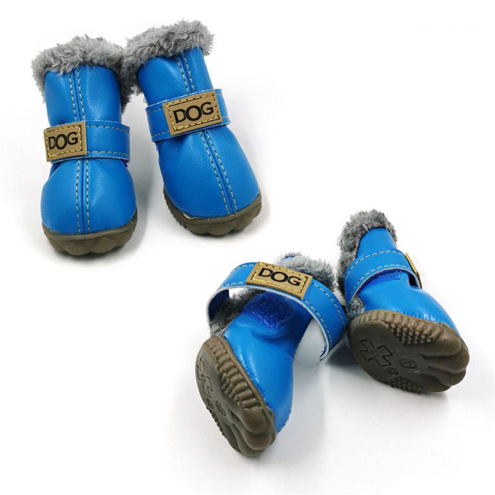 Blue waterproof dog snow boots with gray fuzzy cuffs and tan “DOG” brand patches