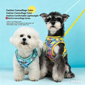Dogs wearing reflective camo mesh harnesses with leashes: white dog blue, dark dog multicolor