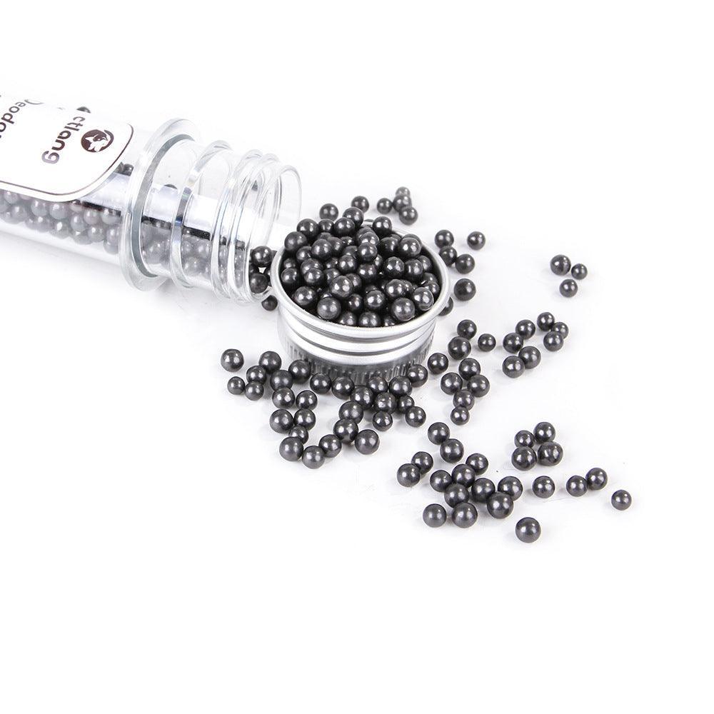 Pouring black activated carbon beads from deodorizer vial onto white surface