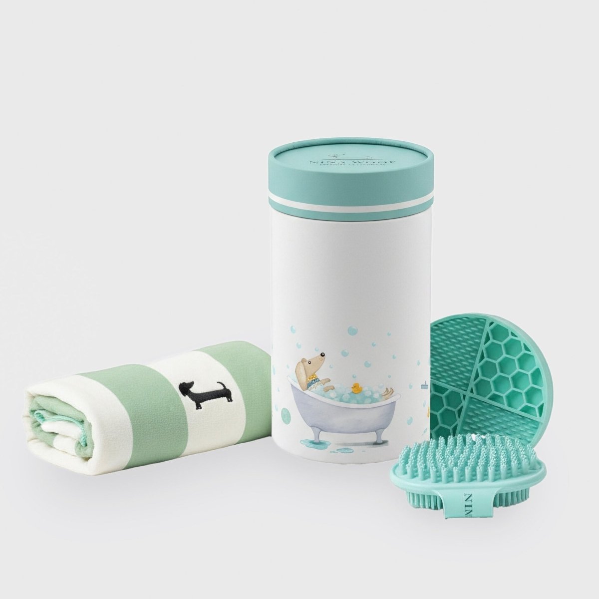 Mint and white dog bath kit container, rolled towel, and teal silicone brush