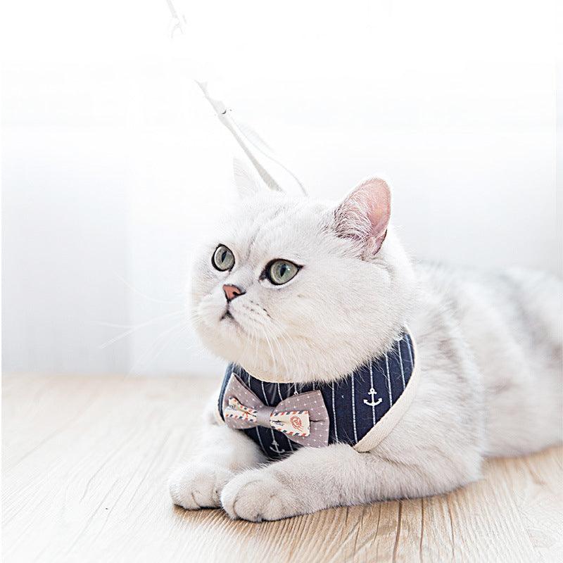 Cat wearing navy anchor-pattern mesh harness with bow tie and attached leash
