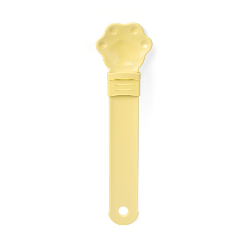 Cat treat squeeze spoon in yellow with paw-shaped dispensing tip and grip handle