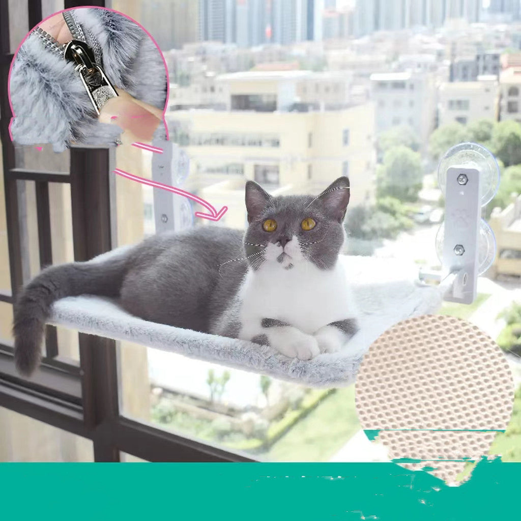Grey-and-white cat on grey plush window hammock with suction cup brackets and mesh pad