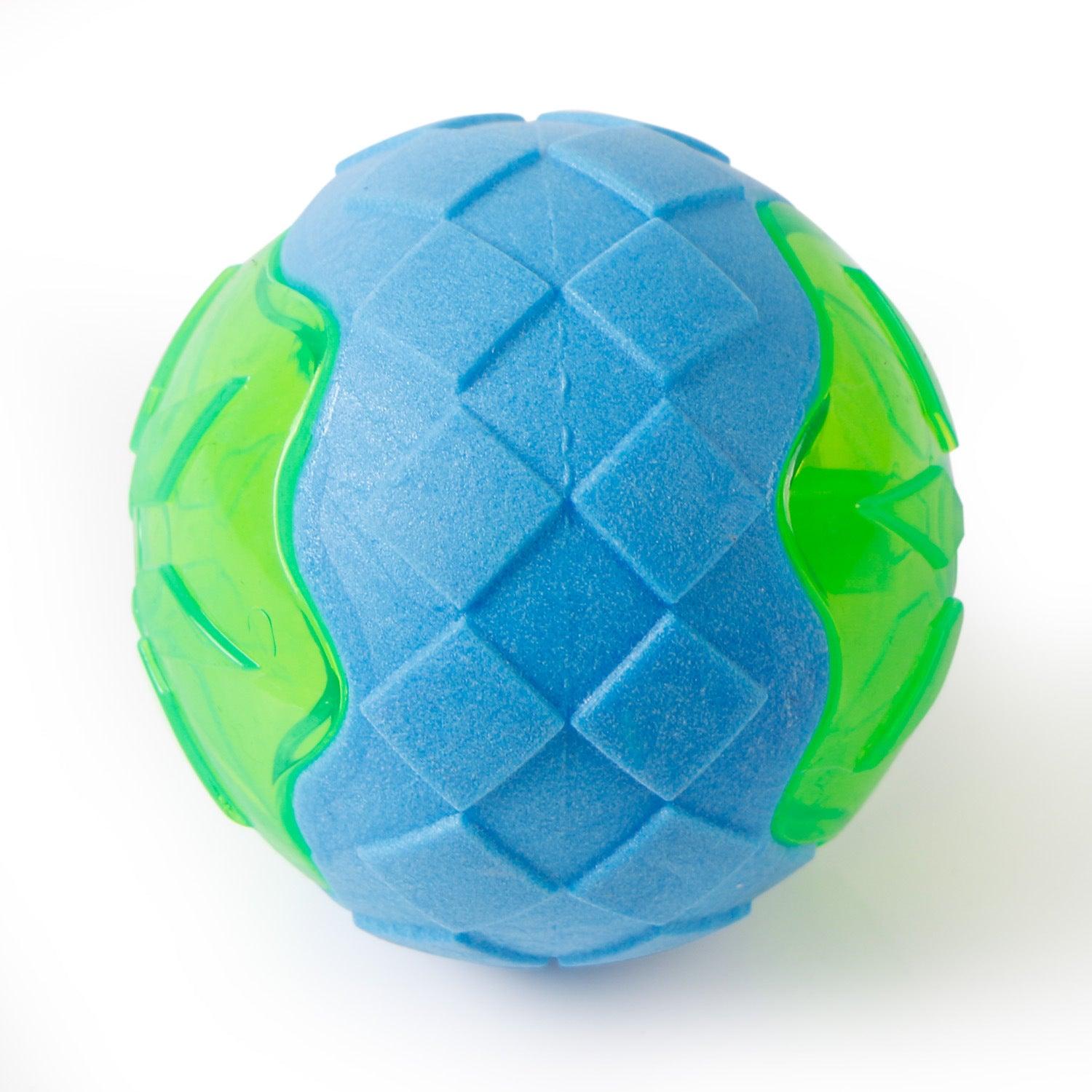 Close-up of glowing audible dog toy ball in blue with green outer section and ridges
