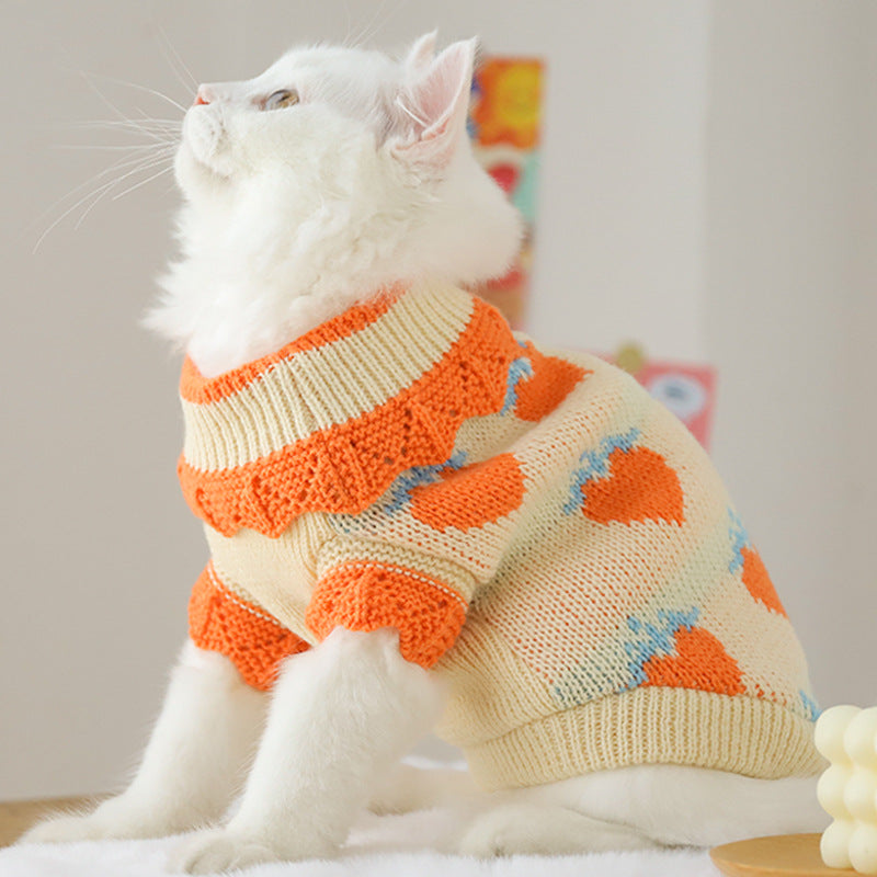 Cat sweater in cream knit with orange collar and blue-and-orange heart patterns