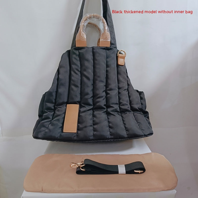 Black quilted pet shoulder bag with beige fleece hood and tan handle accents