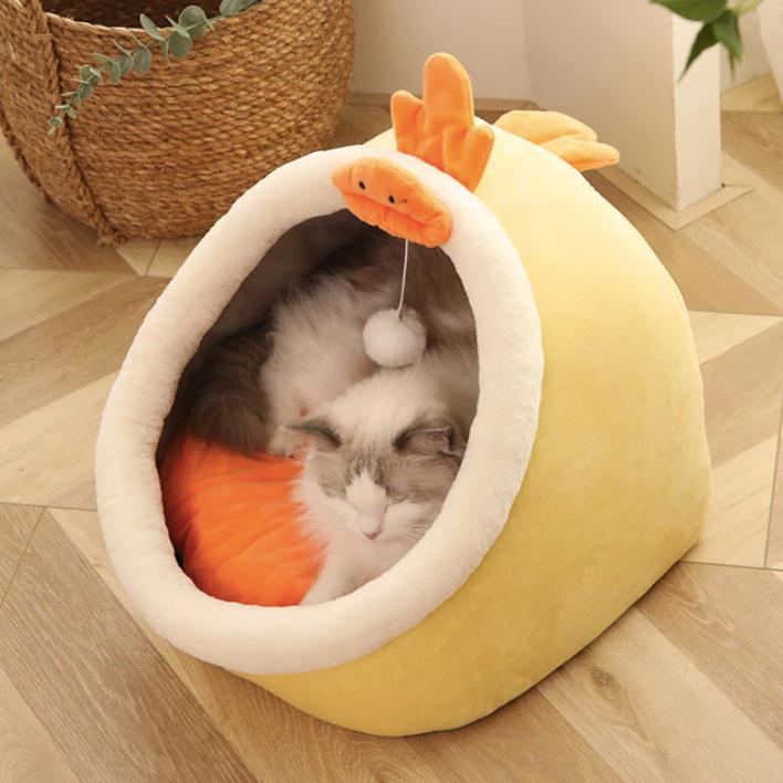 Cream cat bed with orange plush toy, cozy enclosed nest for cats