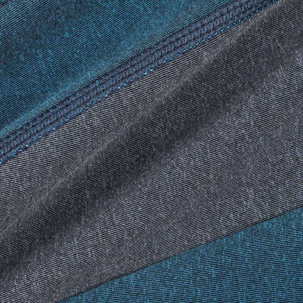 Close-up of teal and gray dog tracksuit fabric with stitched seam detail