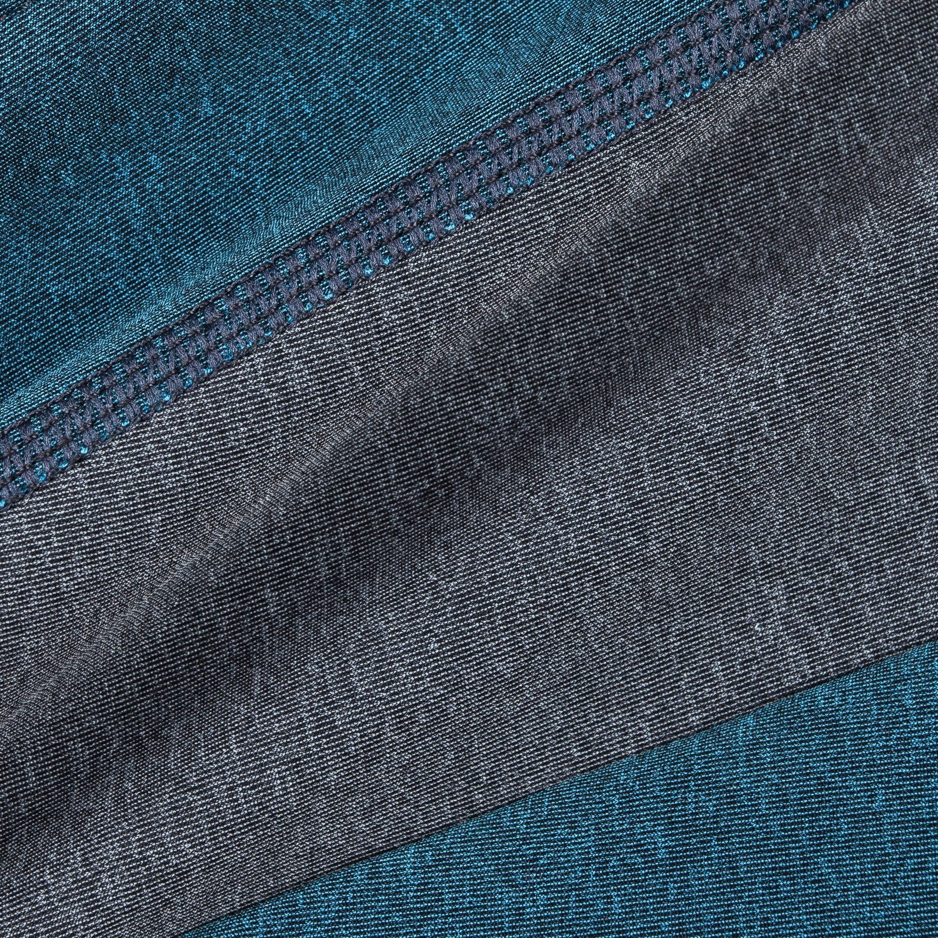 Close-up of teal and gray dog tracksuit fabric with stitched seam detail