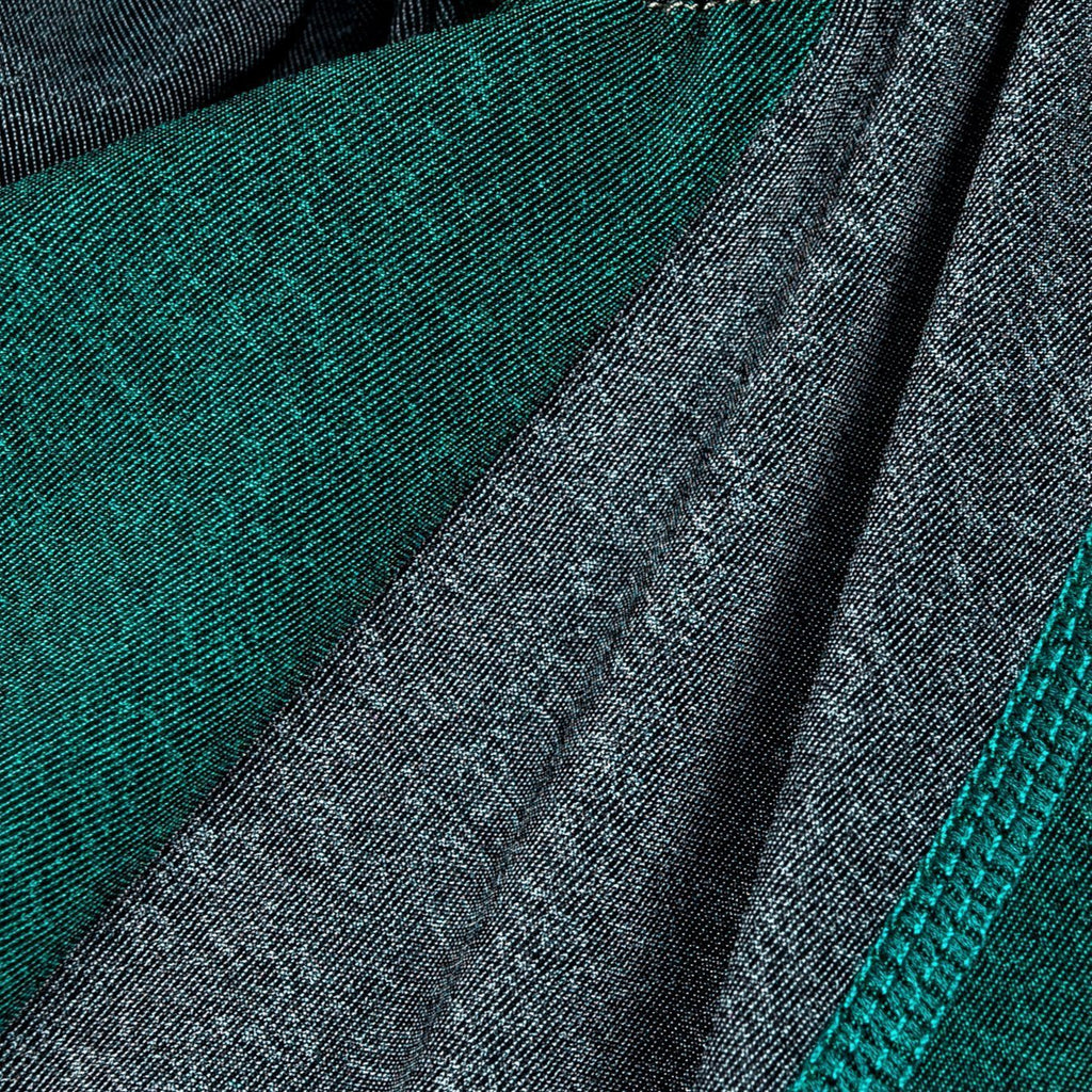 Close-up of green and gray dog tracksuit fabric with stitched seam detail