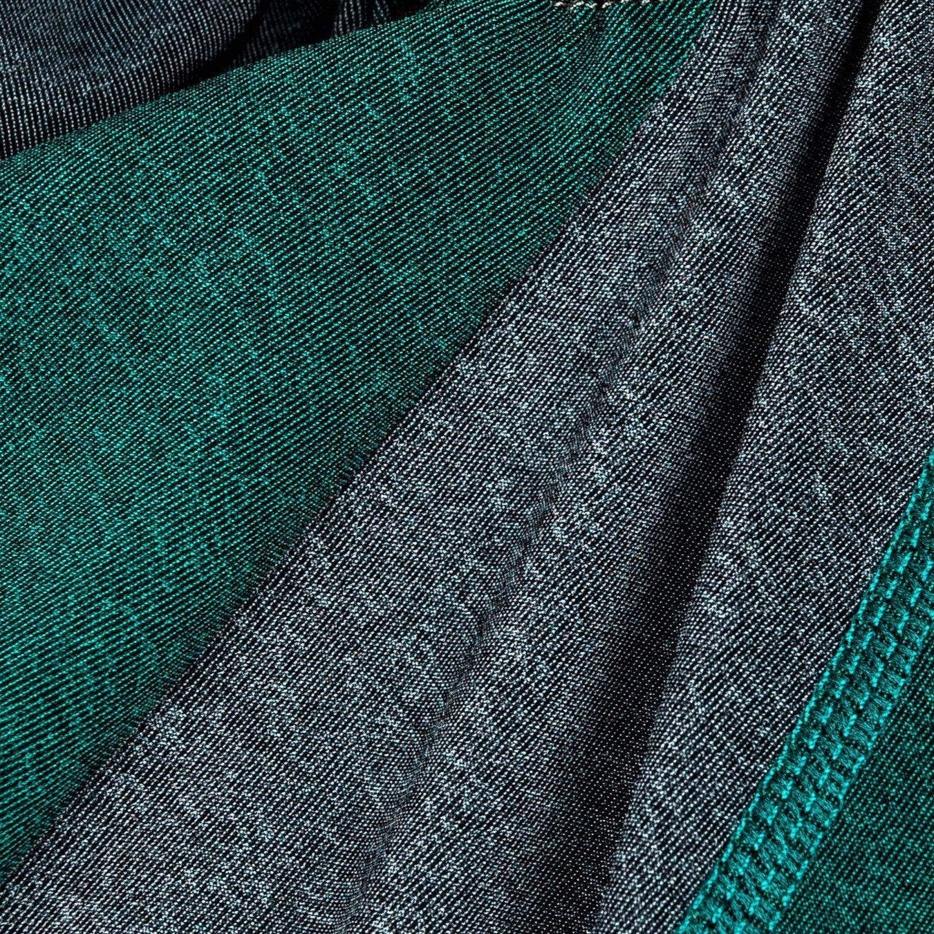 Close-up of green and gray dog tracksuit fabric with stitched seam detail
