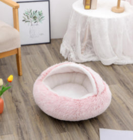 Round pink plush pet bed shown from the side, with padded fuzzy rim and center