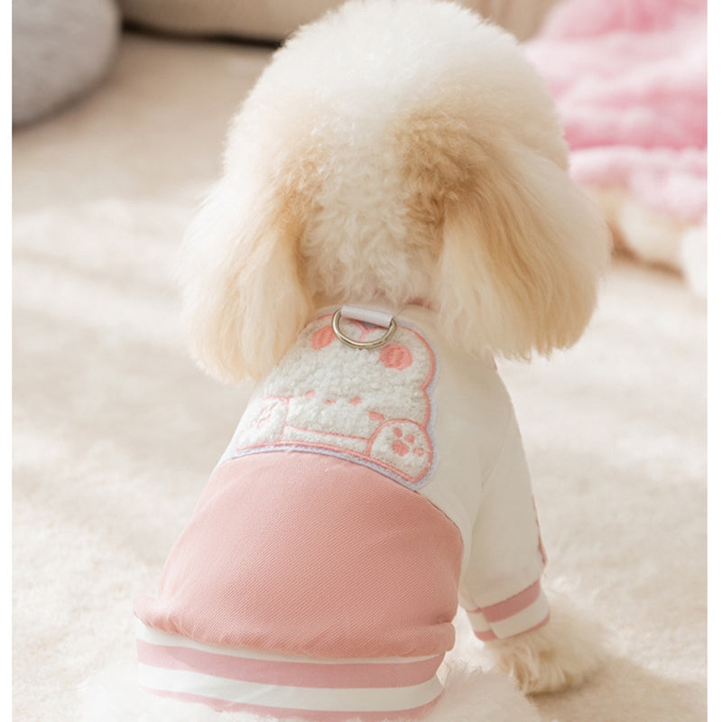 Back view of a dog in a pink-and-white pet jacket with bunny embroidery and leash ring