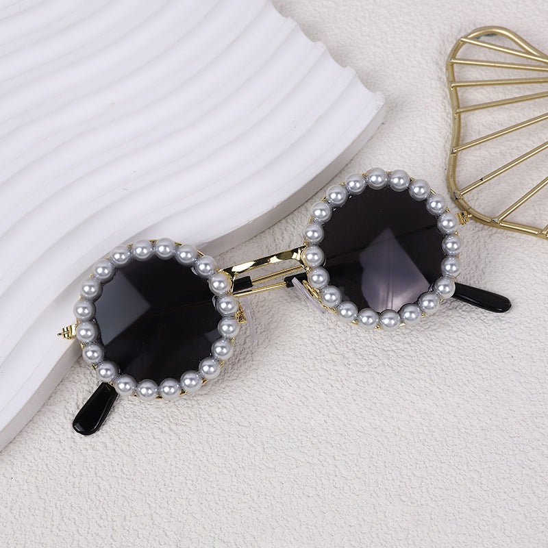 Round pearl sunglasses accessory with dark lenses and black arms