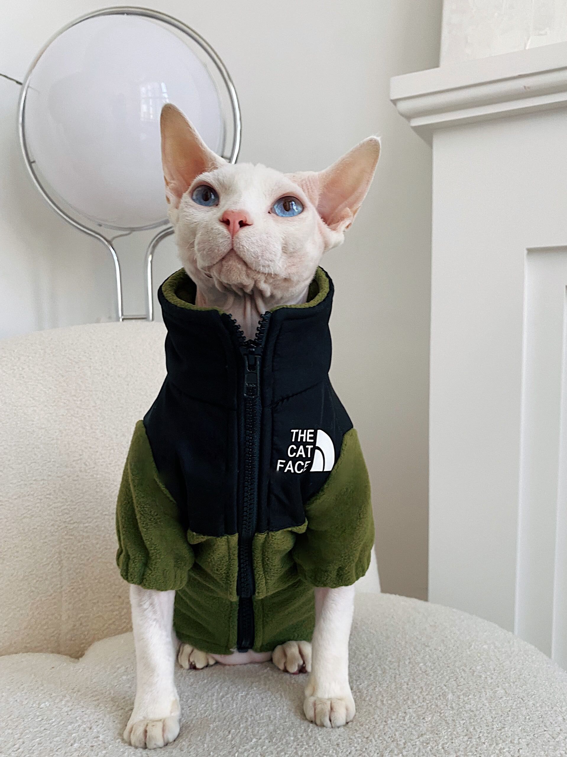 Olive green fleece cat jacket with zipper and hood, front 'THE CAT FACE' chest patch.