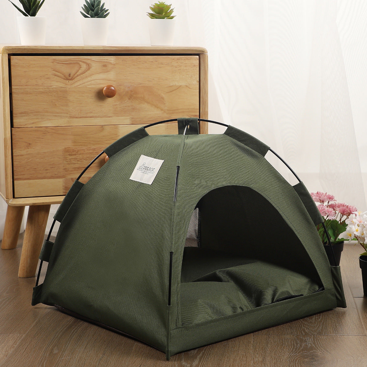 Green teepee-style pet tent with arched entrance and cushioned interior base