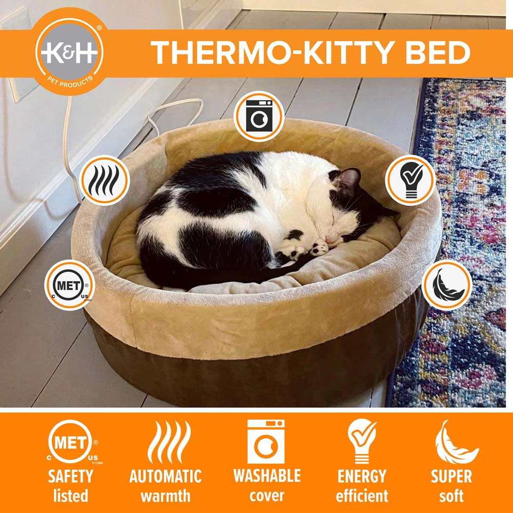 Heated cat bed with light inner cushion and brown outer cover, with black-and-white cat curled up