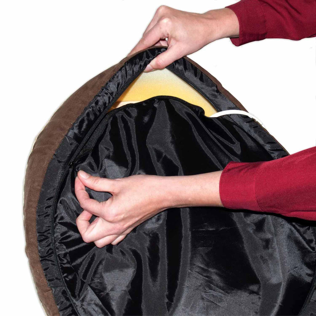 Heated cat bed cover zipper partially open, hands lifting the inner liner