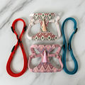 Boho dog harness vests with tassels and tribal pattern, shown with pink and beige leashes