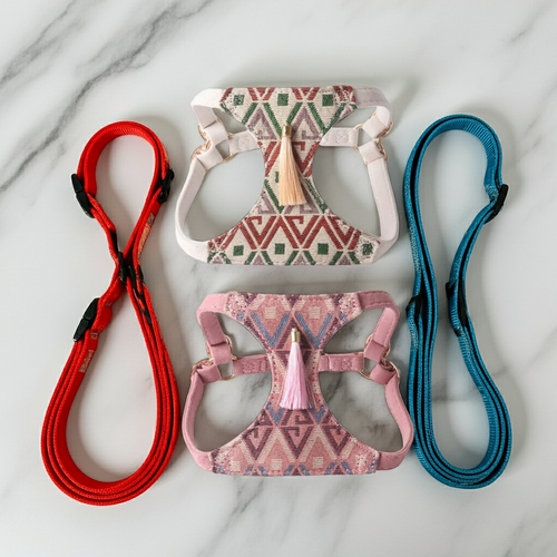 Two dog harness and leash sets with tassel accents in pink and beige