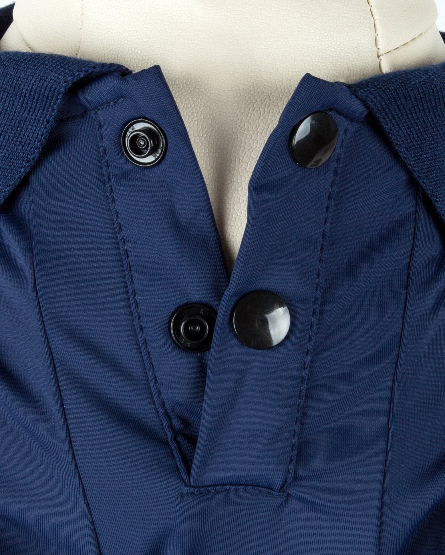 Navy dog polo close-up: snap buttons and stitched placket