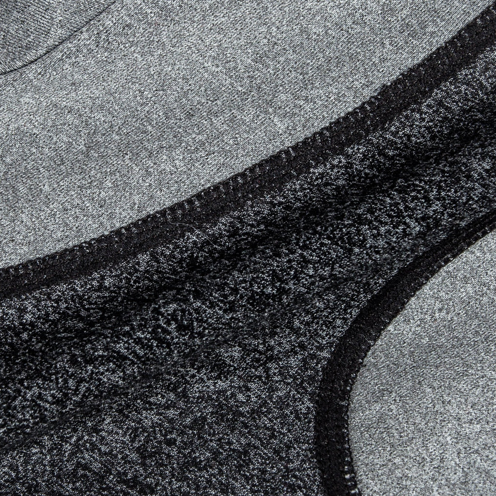 Close-up of dark heather knit with light gray panel and black edge stitching