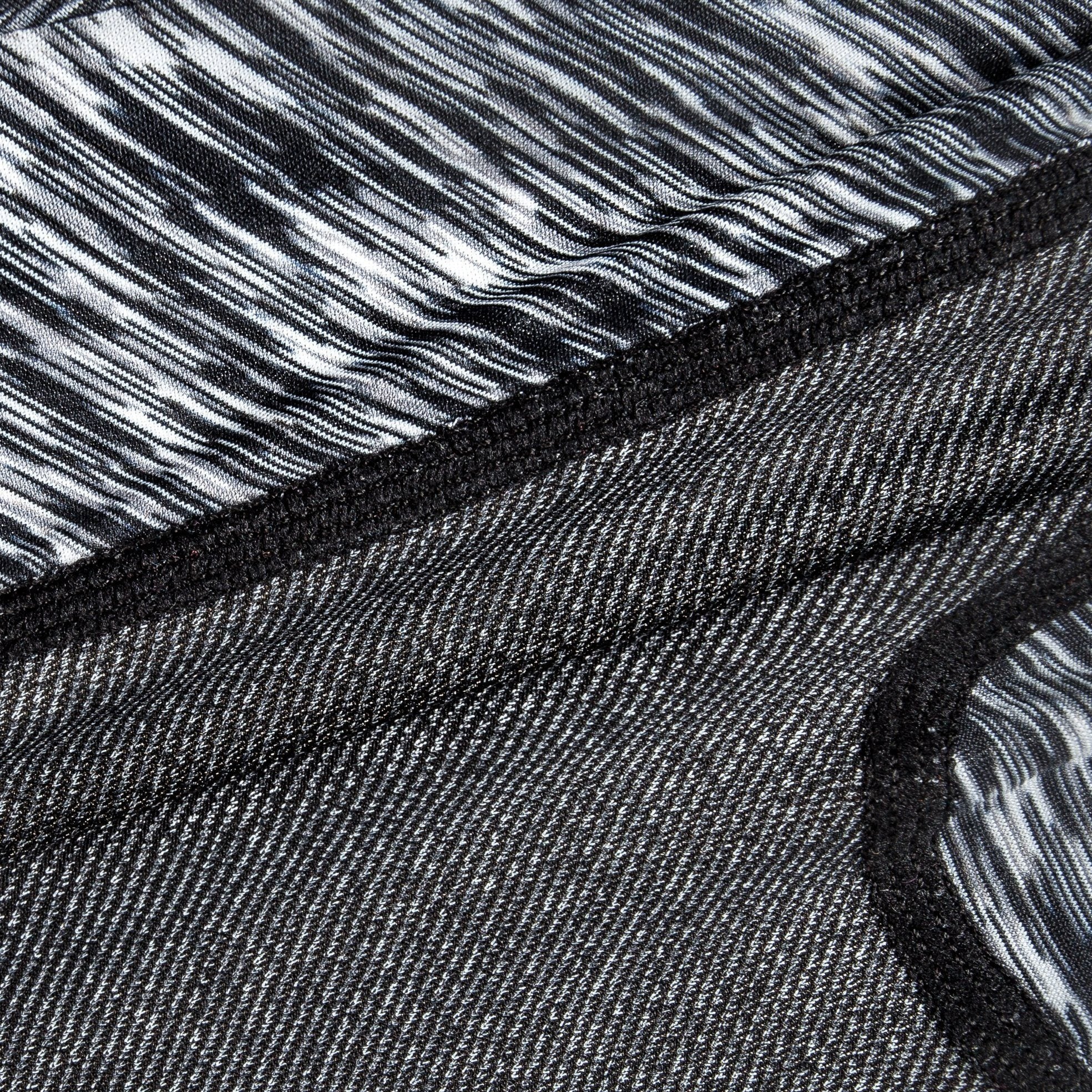 Black heather-knit fabric close-up with stitched edge and inner striped panel