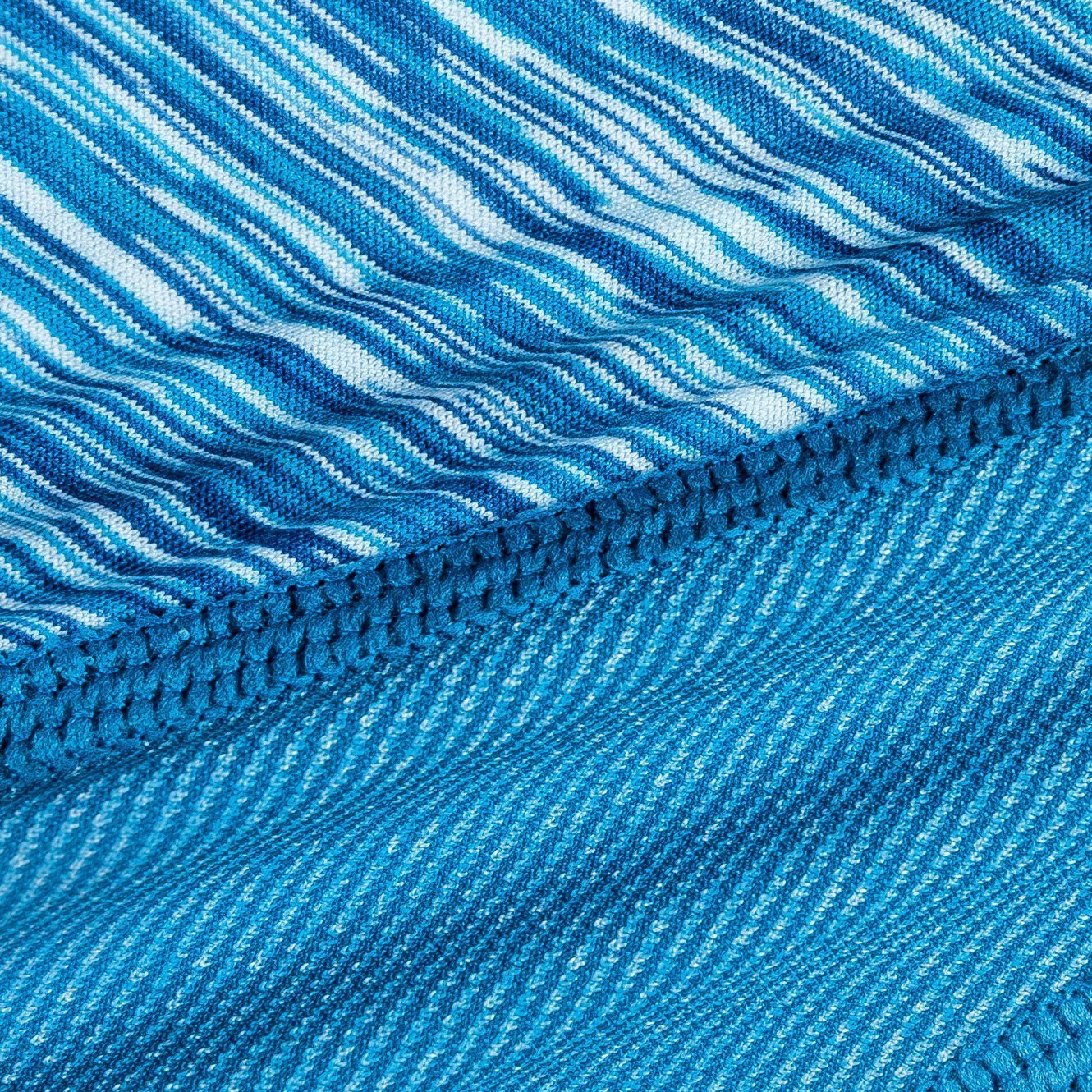 Blue striped fabric close-up with textured weave and stitched seam trim
