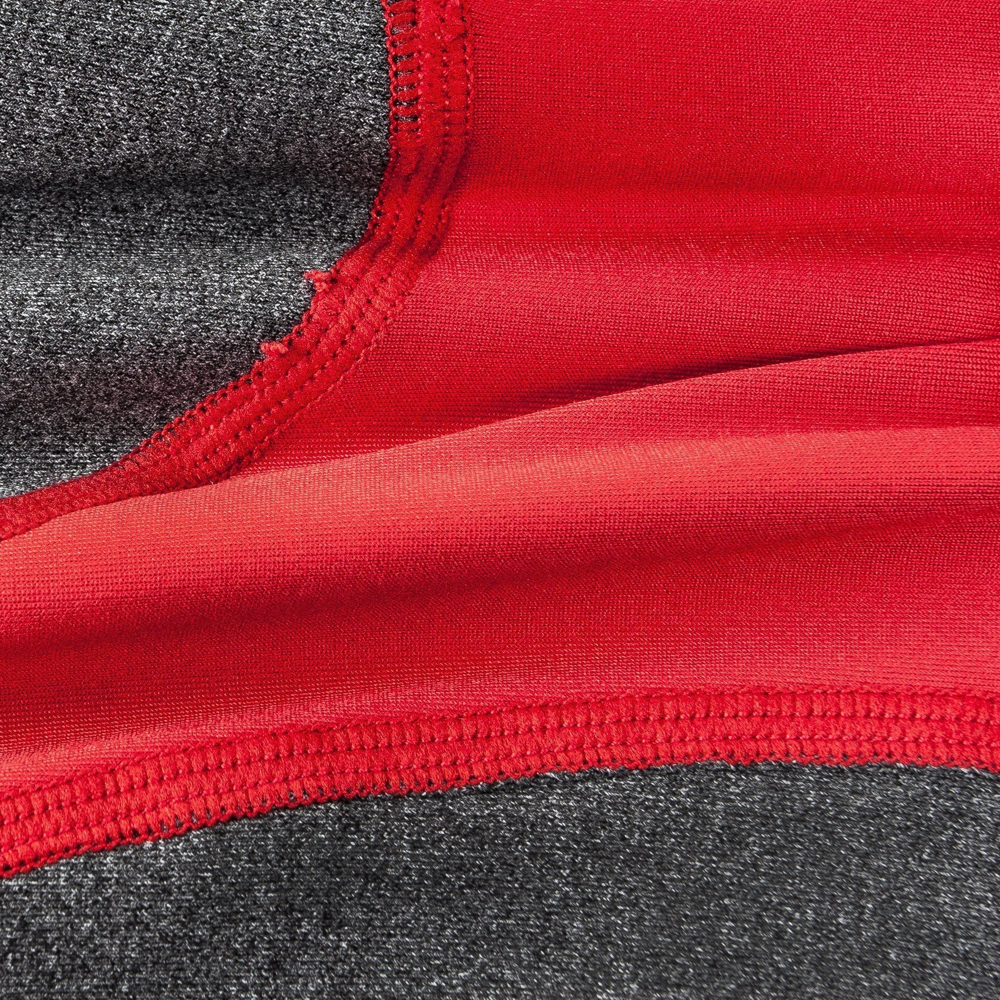 Close-up of red and dark gray dog tracksuit fabric with stitched seam detail