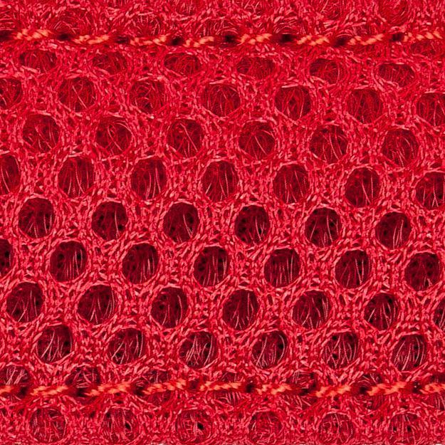 Close-up of red breathable mesh fabric with circular ventilation holes