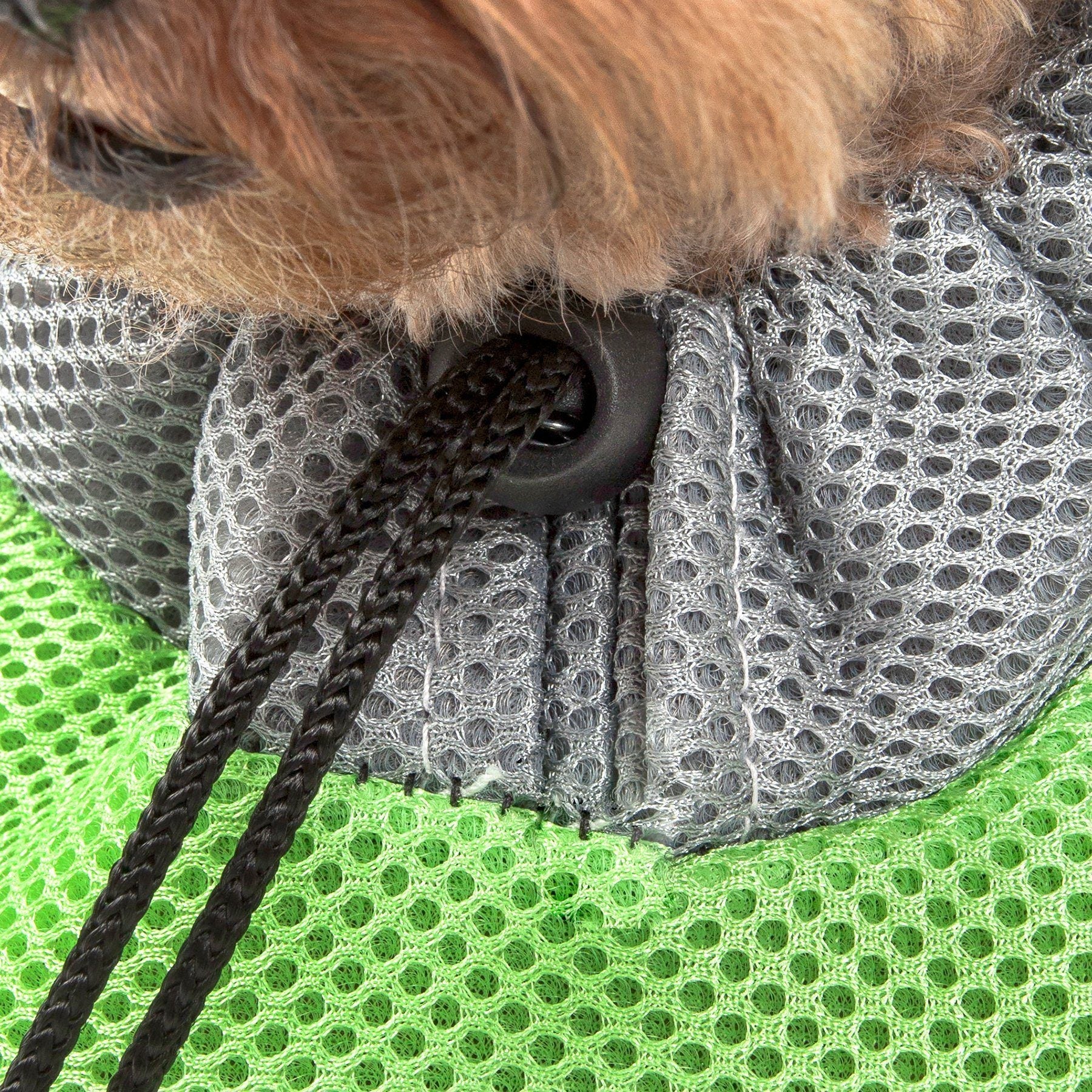 Green mesh and gray fabric pocket of a dog backpack carrier with black drawstring.